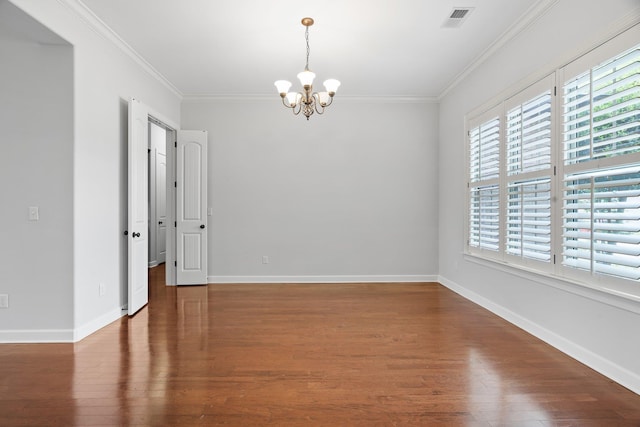 empty room featuring ornamental molding, an inviting chandelier, wood finished floors, and visible vents