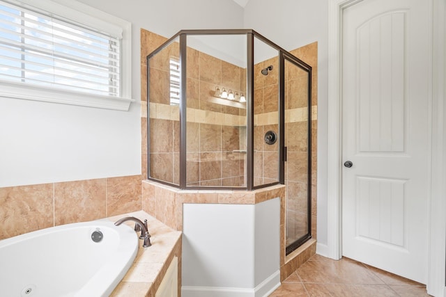bathroom with a shower stall, a whirlpool tub, and tile patterned flooring
