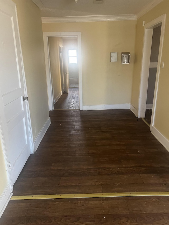 corridor featuring ornamental molding, dark wood-style floors, and baseboards