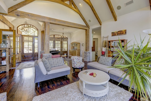 living area with visible vents, hardwood / wood-style flooring, an inviting chandelier, and high vaulted ceiling