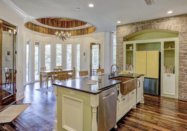 kitchen featuring a sink, dark countertops, freestanding refrigerator, dishwasher, and dark wood finished floors