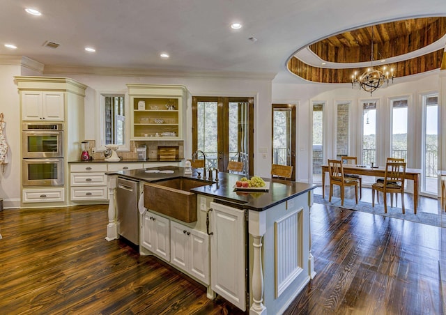 kitchen with stainless steel appliances, dark countertops, a sink, dark wood-style floors, and visible vents