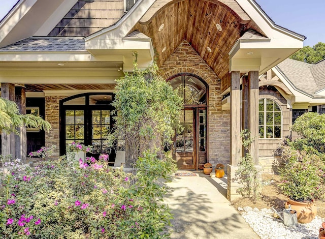 entrance to property with french doors and roof with shingles