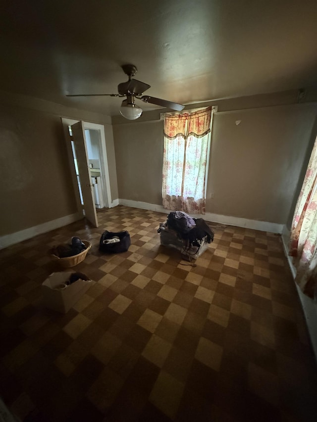 interior space featuring baseboards and a ceiling fan