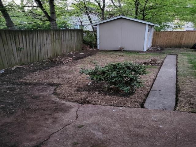 view of yard with an outdoor structure, a shed, and a fenced backyard