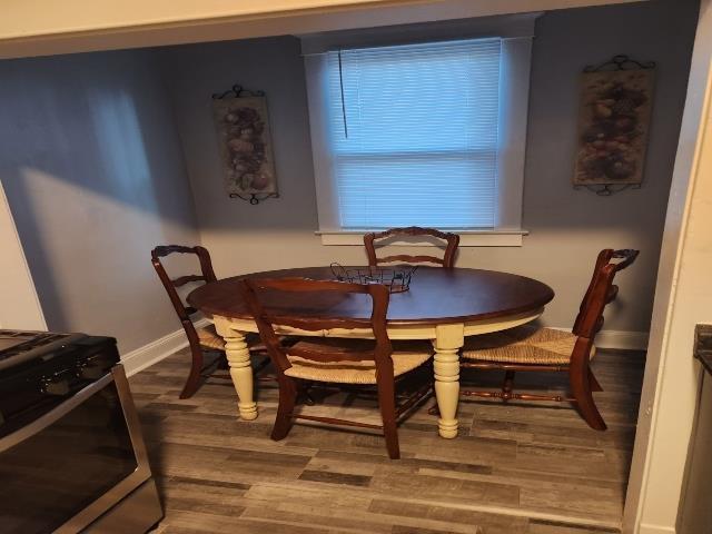 dining space featuring wood finished floors and baseboards