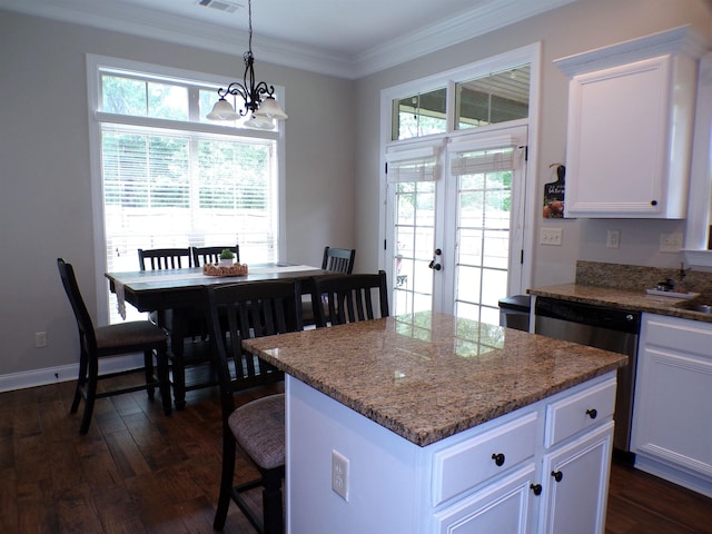 kitchen with dark wood-style flooring, stainless steel dishwasher, a notable chandelier, and a kitchen island