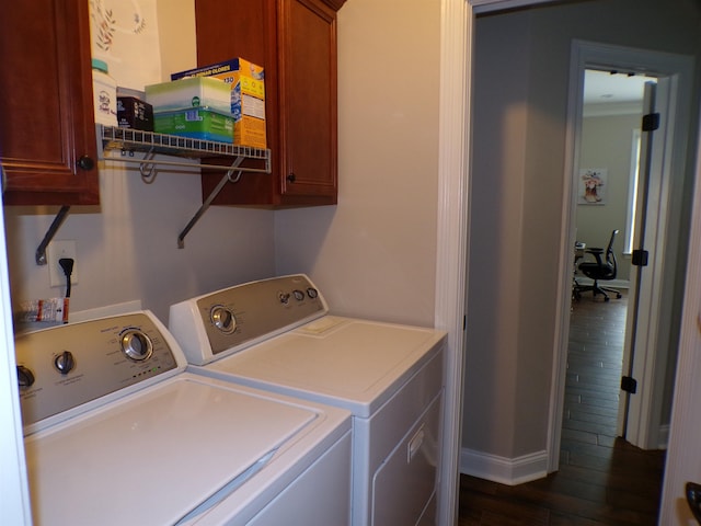 washroom with dark wood-style floors, cabinet space, and washing machine and clothes dryer