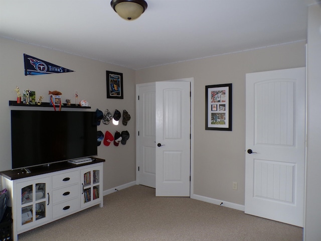 interior space with baseboards and light carpet