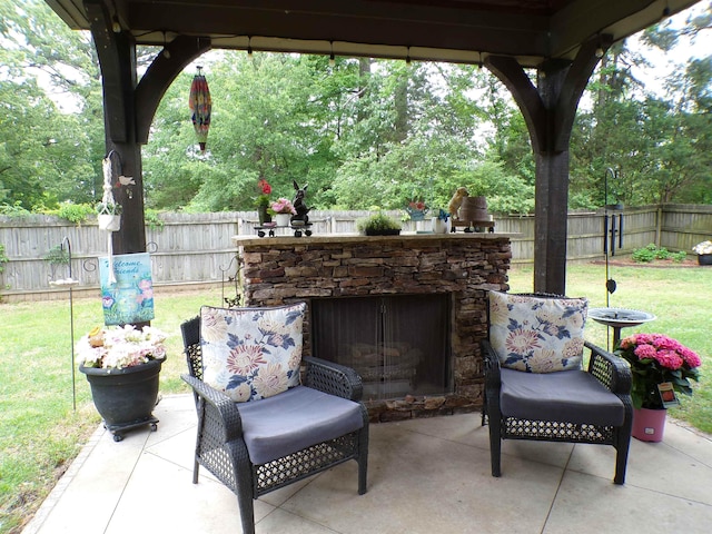 view of patio / terrace featuring a fenced backyard and an outdoor stone fireplace
