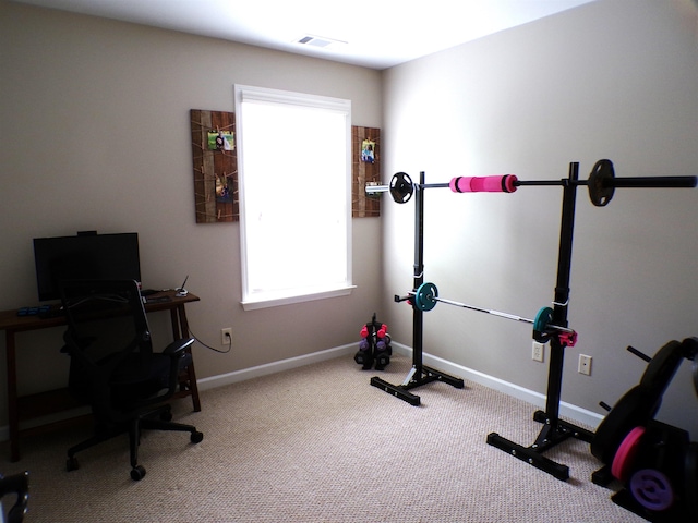 exercise area featuring baseboards, visible vents, and carpet floors