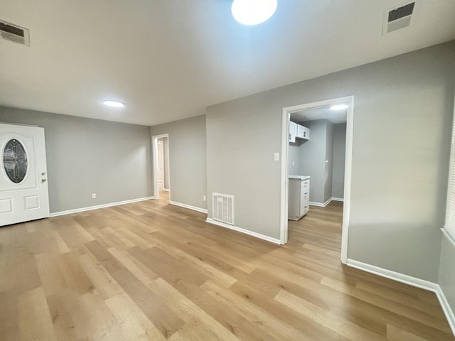 interior space with visible vents, light wood-style floors, and baseboards