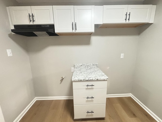 interior space with baseboards and wood finished floors