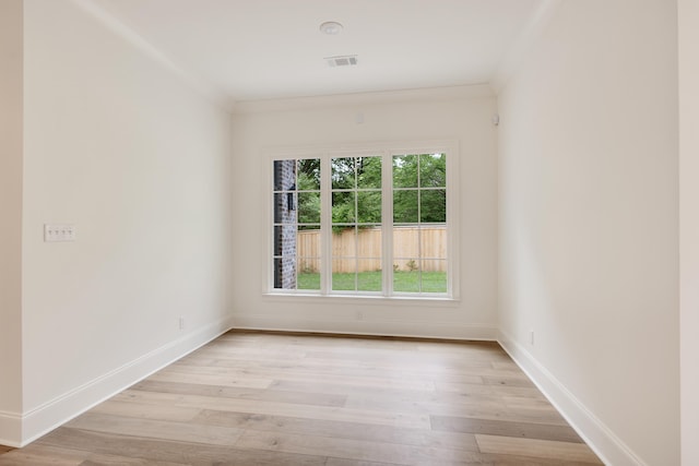 spare room featuring baseboards, light wood-style flooring, and visible vents