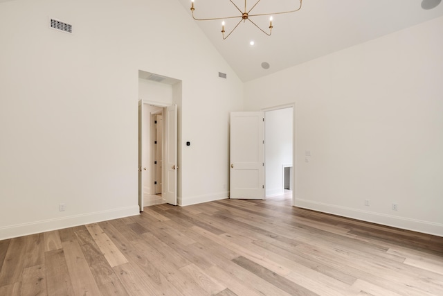 unfurnished room featuring light wood-style floors, visible vents, high vaulted ceiling, baseboards, and an inviting chandelier