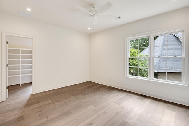 spare room featuring baseboards, a ceiling fan, wood finished floors, and visible vents
