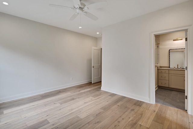 unfurnished bedroom featuring a sink, ensuite bath, light wood-style floors, recessed lighting, and baseboards