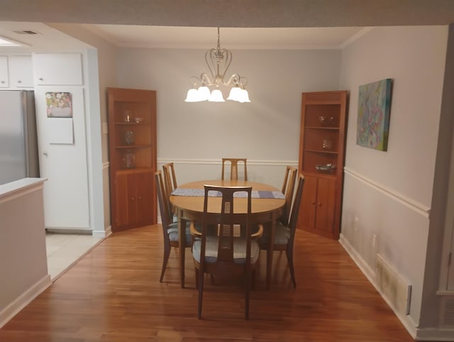 855 Creekside St Unit 303, Memphis, TN 38117 - dining space featuring crown molding, a notable chandelier, visible vents, and light wood-type flooring
