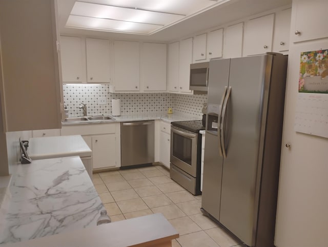 855 Creekside St Unit 303, Memphis, TN 38117 - kitchen with white cabinets, appliances with stainless steel finishes, a sink, light tile patterned floors, and backsplash