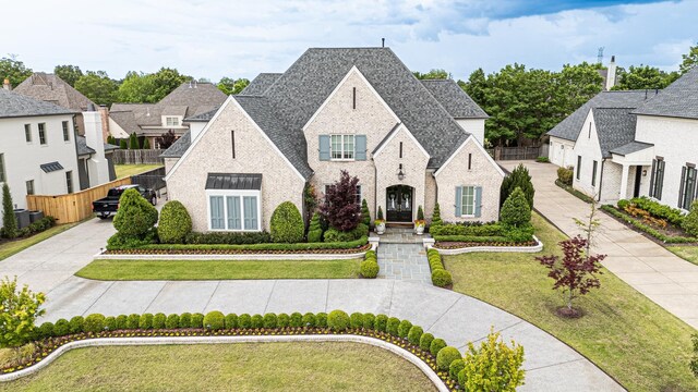 view of front of property with brick siding and a shingled roof