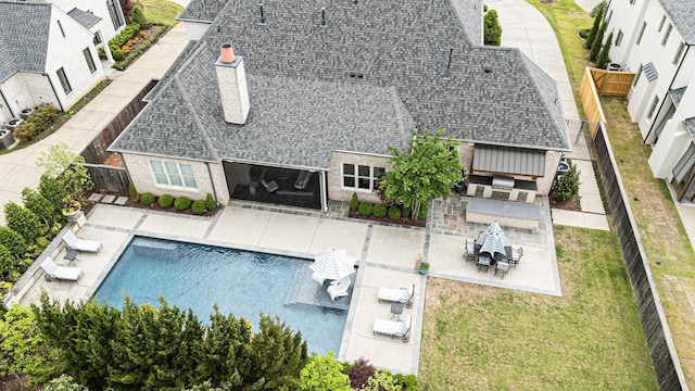 rear view of property with a patio area, a shingled roof, and an outdoor pool
