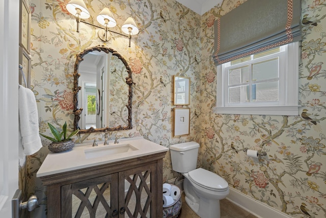 bathroom featuring wallpapered walls, toilet, vanity, and baseboards