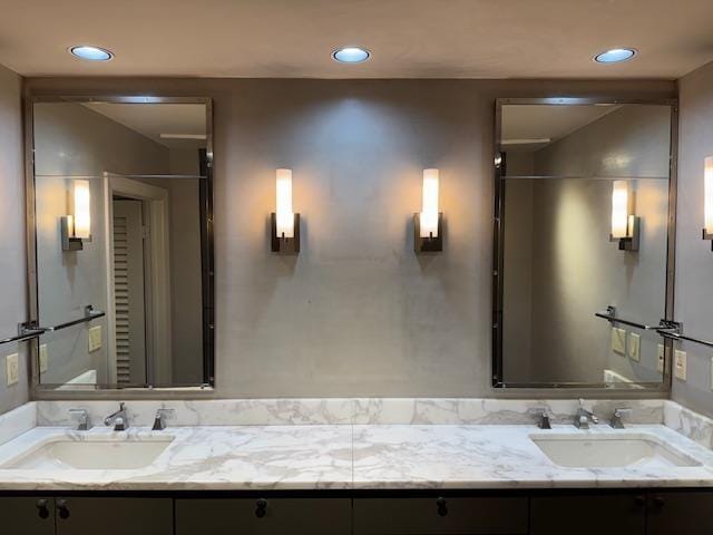 full bathroom featuring double vanity, recessed lighting, and a sink