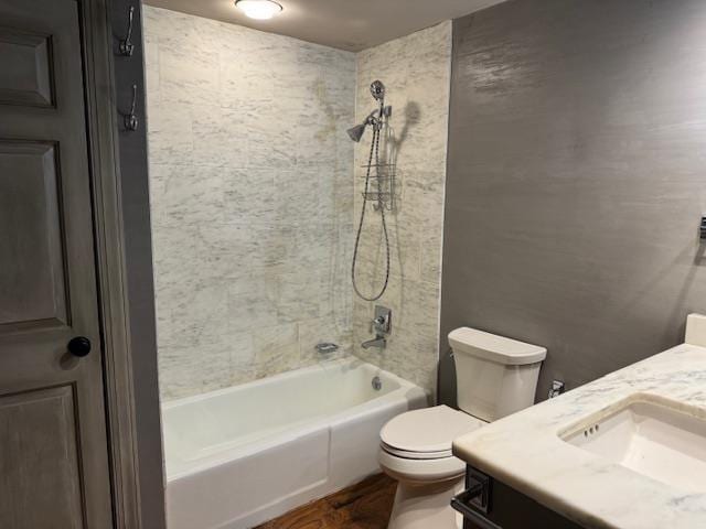 bathroom with washtub / shower combination, vanity, and toilet