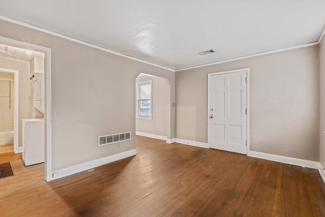 3684 Marion Ave, Memphis, TN 38111 - empty room featuring wood-type flooring, arched walkways, baseboards, washer / dryer, and visible vents