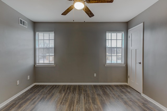 spare room featuring visible vents, a ceiling fan, baseboards, and wood finished floors