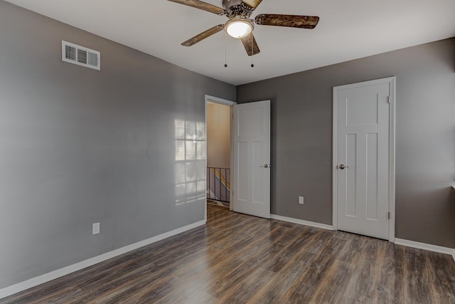 unfurnished bedroom featuring baseboards, ceiling fan, wood finished floors, and visible vents