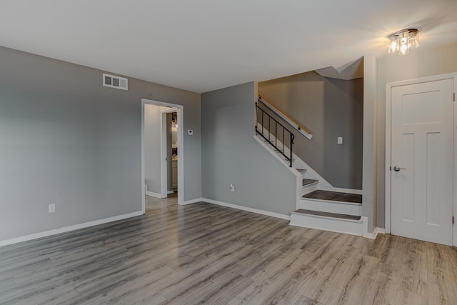 interior space featuring stairs, baseboards, visible vents, and wood finished floors