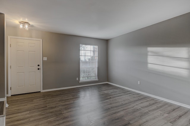 empty room featuring baseboards and wood finished floors