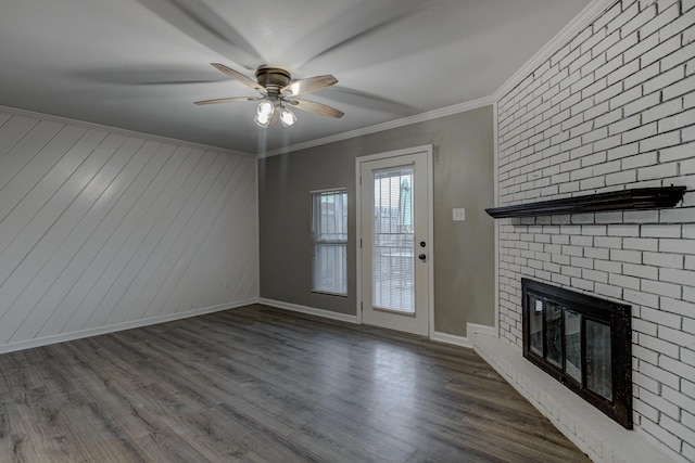 unfurnished living room with crown molding, wood finished floors, a fireplace, baseboards, and ceiling fan