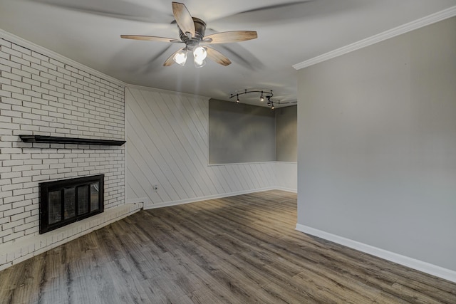 unfurnished living room with crown molding, ceiling fan, wood finished floors, and a fireplace