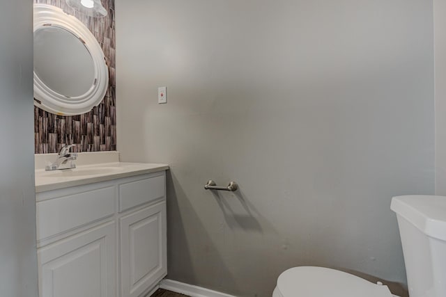 bathroom with vanity, baseboards, and toilet