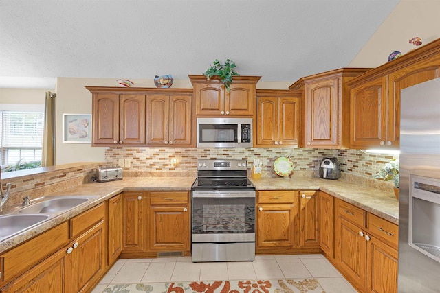 165 Ping Hill Dr, Counce, TN 38326 - kitchen with a textured ceiling, appliances with stainless steel finishes, light tile patterned floors, and tasteful backsplash