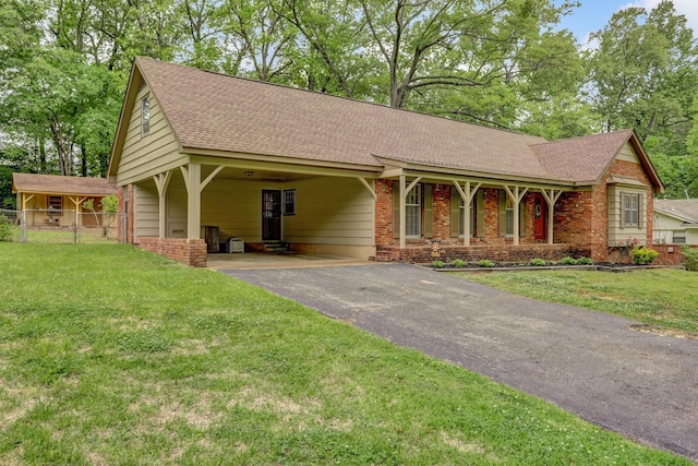 single story home with a front yard, fence, aphalt driveway, a shingled roof, and an attached carport