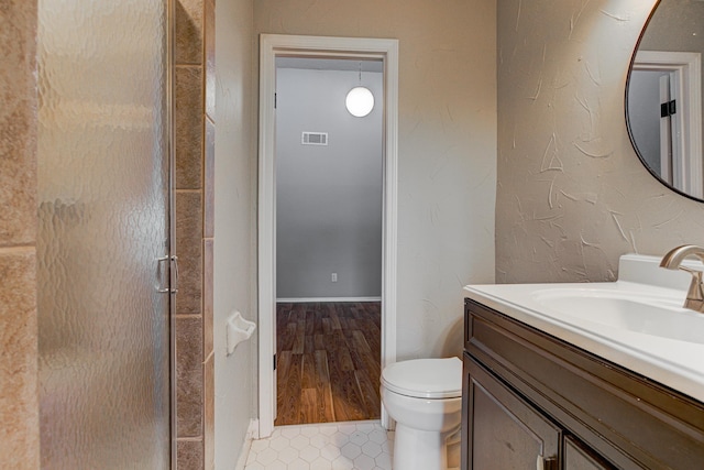 bathroom with vanity, a stall shower, visible vents, and toilet