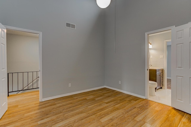 unfurnished room featuring baseboards, visible vents, and light wood finished floors