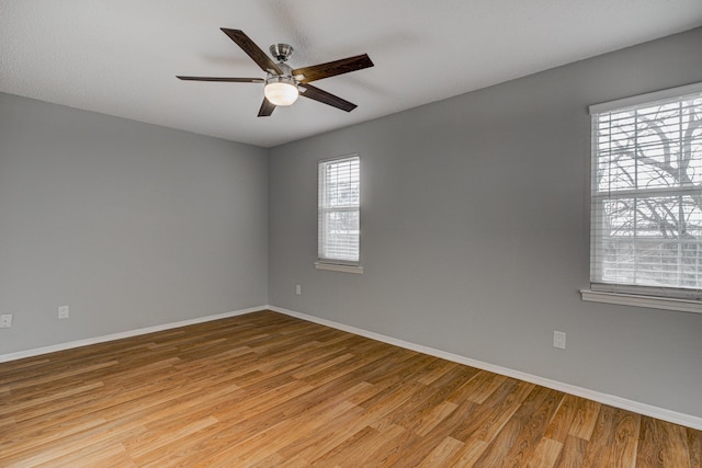 unfurnished room featuring ceiling fan, baseboards, and light wood finished floors