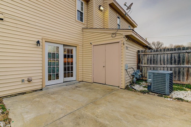 entrance to property featuring central AC, fence, and a patio area