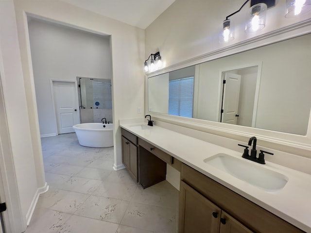 bathroom featuring baseboards, a sink, and a freestanding tub
