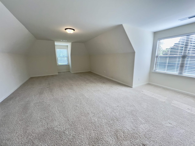 bonus room featuring baseboards, carpet flooring, lofted ceiling, and visible vents