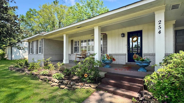 254 S White Station Rd, Memphis, TN 38117 - entrance to property with visible vents, brick siding, board and batten siding, a porch, and a yard
