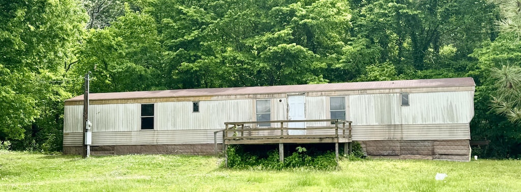back of property featuring a yard and a deck