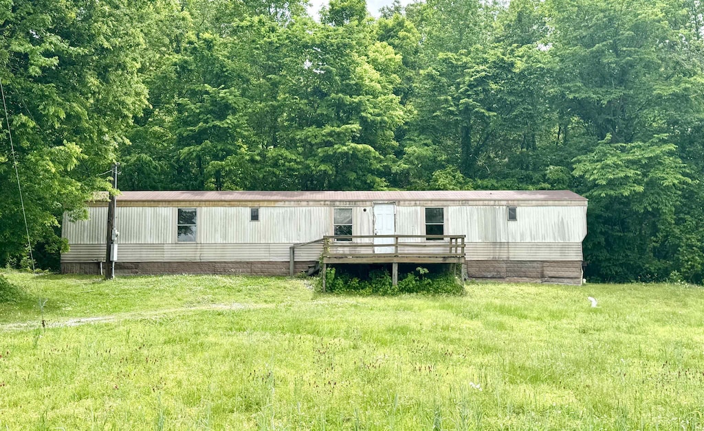 rear view of house with a view of trees and a wooden deck