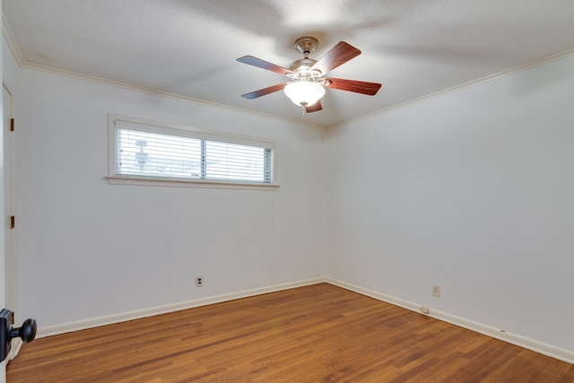 empty room with ornamental molding, ceiling fan, and wood finished floors