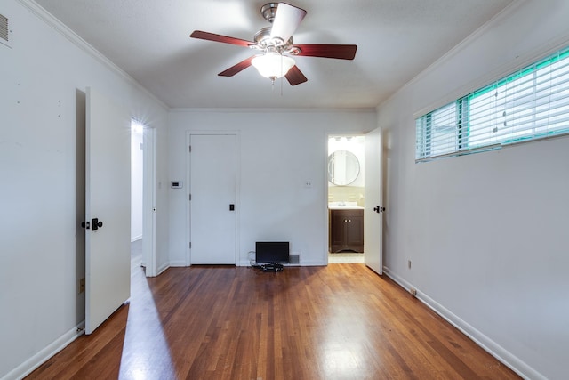 spare room featuring ceiling fan, ornamental molding, wood finished floors, and visible vents