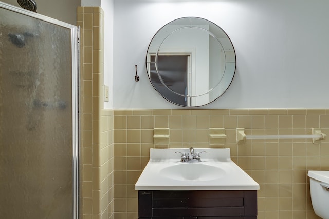 bathroom featuring vanity, tile walls, a stall shower, and toilet